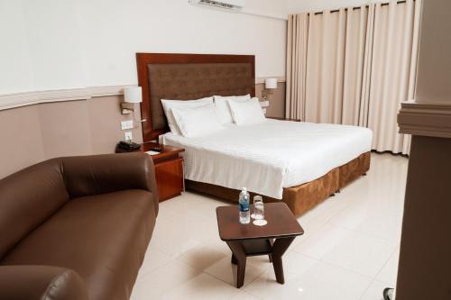 Habitación de hotel con cama y sofá en Great Zimbabwe Hotel en Masvingo