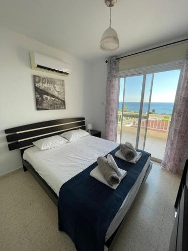 a bedroom with a large bed with towels on it at Serenity Corner in Paphos