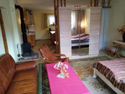Górski Zakątek z kominkiem i tarasem في Laliki: غرفة معيشة بها أريكة وطاولة عليها زهور