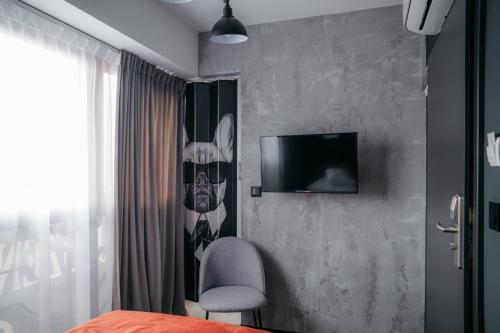a bedroom with a bed and a tv on a wall at SLEEP WELL 1999 in Tychy