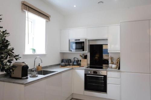 a white kitchen with a sink and a stove at BOURNECOAST - TOWN CENTRE - BEACH 10 min WALK - GARDEN PATIO - 8421 in Bournemouth