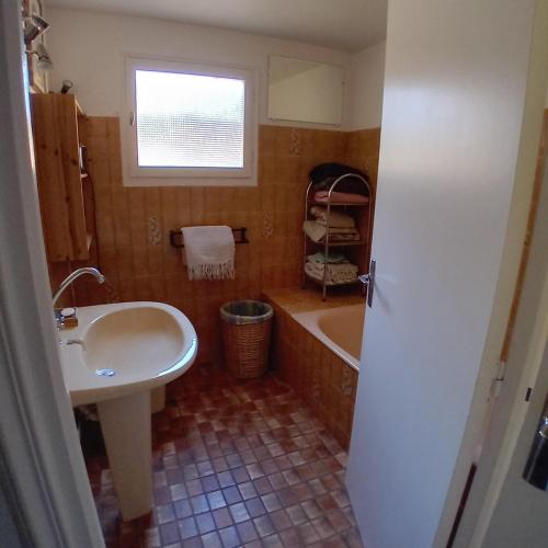 une salle de bain avec un lavabo et une baignoire et un lavabo dans l'établissement Maison dans écrin de verdure en Périgord noir, à Saint-Cyprien