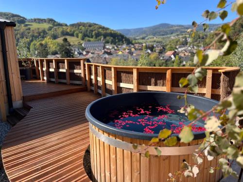 a hot tub on a deck with a view at Domaine des Constellations - Tiny Houses & Bains Nordiques in Orbey