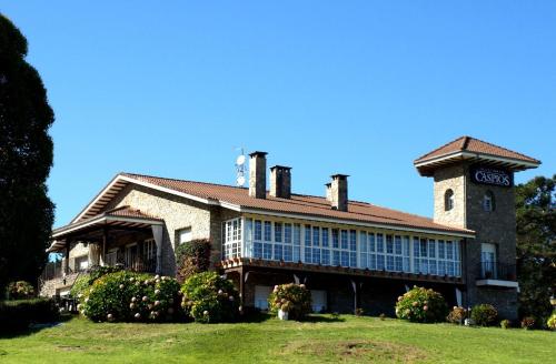 een groot bakstenen gebouw met een toren erop bij Hotel Los Caspios in Colunga