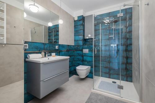a bathroom with a toilet and a glass shower at Air-Conditioned Seaside Apartment with Parking & Balcony by Renters in Ustronie Morskie