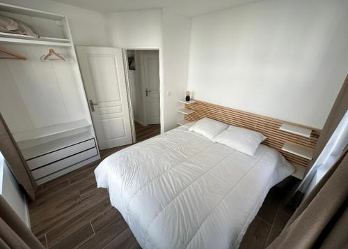 een slaapkamer met een wit bed in een kamer bij Appartement spacieux et tout confort in Le Pouliguen