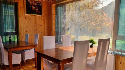 une salle à manger avec une table en bois et des chaises blanches dans l'établissement Terelj Altai Resort, à Nalayh