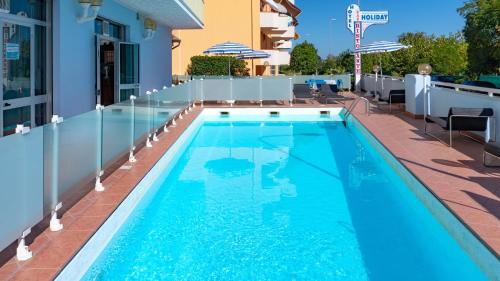 a swimming pool with blue water in a building at Hotel Holiday in Martinsicuro
