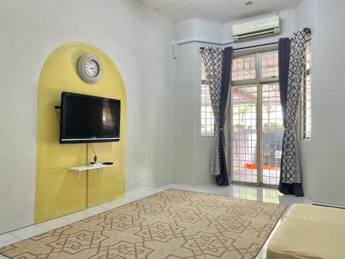 a living room with a flat screen tv on a wall at Ruwa Homestay in Jitra