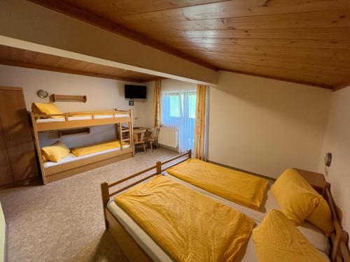 a bedroom with two beds and a bunk bed at Ferienhof Wölflbauer in Saalbach Hinterglemm