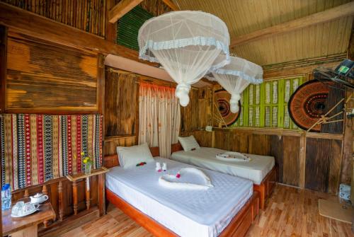 1 Schlafzimmer mit 2 Betten und einem Kronleuchter in der Unterkunft Mu Cang Homestay in Lao San Chay