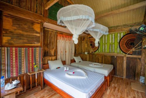 a bedroom with two beds and a chandelier at Mu Cang Homestay in Lao San Chay