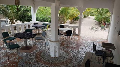 a patio with tables and chairs on a porch at SANYANG in Sanyang