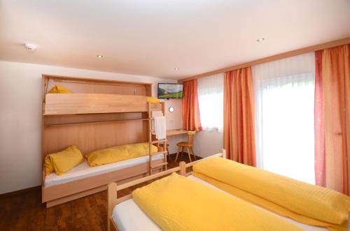 a bedroom with two bunk beds with yellow pillows at Ferienhof Wölflbauer in Saalbach Hinterglemm