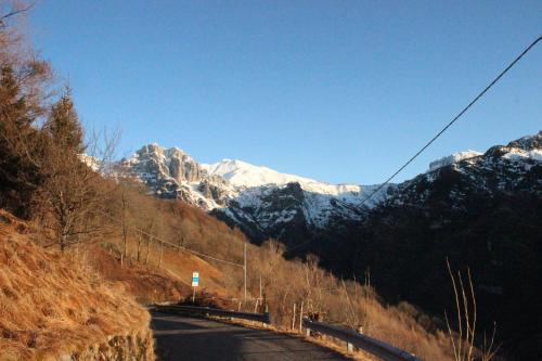 a road in the mountains with snow covered mountains at B&B Piccolo Tibet in Lavenone