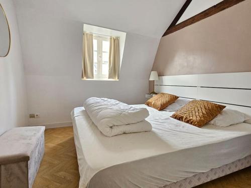 um quarto branco com uma cama grande e uma janela em Place Morny, maison de ville, 2 chambres, terrasse em Deauville