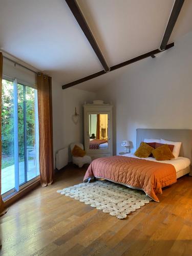 - une chambre avec un lit et une grande fenêtre dans l'établissement Au Bois Dormant, à Chilly-Mazarin