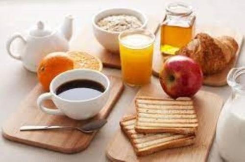 a table with a breakfast of coffee and breakfast foods at The Rooms of Vilmorais - Violette Prince in Arcomps