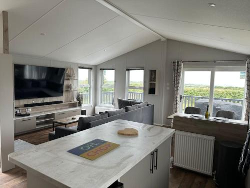 sala de estar con sofá y mesa en Modern Lodge with Amazing Views en Newquay
