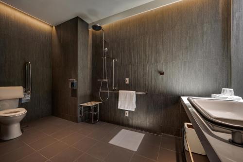 a bathroom with a shower and a toilet and a sink at Hotel Resonance Taipei, Tapestry Collection by Hilton in Taipei