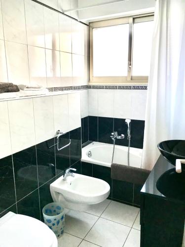 une salle de bain avec toilettes, lavabo et baignoire dans l'établissement Palais Lumière, à Cannes