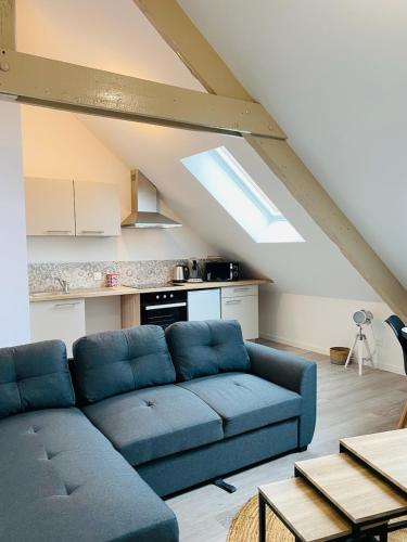 - un salon mansardé avec un canapé bleu dans l'établissement Agréable appartement entièrement refait neuf, à Cherbourg en Cotentin