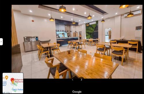 een leeg restaurant met houten tafels en stoelen bij Ma. Awani Hotel & Suites 