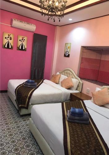 a hotel room with two beds and a chandelier at Tonkaew Khaokao Resort in Campson