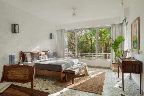 1 dormitorio con cama y ventana grande en La Soria Estate en Assagao