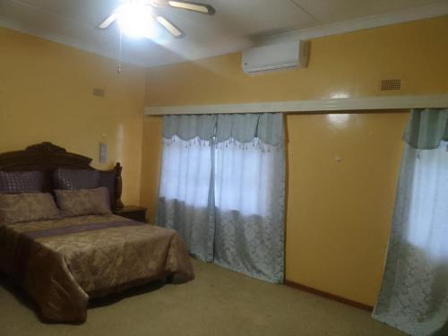 um quarto com uma cama e uma janela com cortinas em Holope Self-Catering Accomm em Prieska