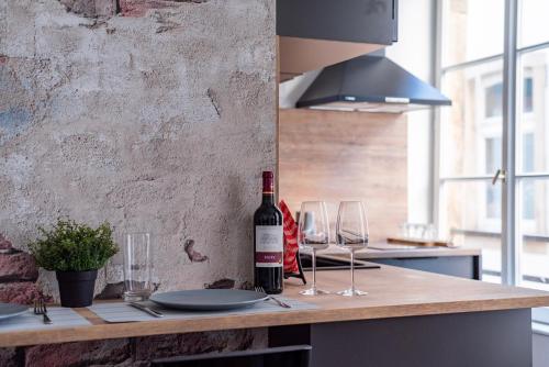 - une bouteille de vin assise sur un comptoir avec des verres à vin dans l'établissement Chez Françoise - Hyper-Centre, vue cathédrale, à Strasbourg