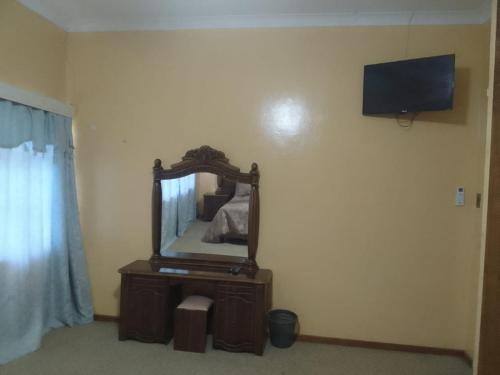 ein Schlafzimmer mit einem Spiegel an der Wand in der Unterkunft Holope Self-Catering Accomm in Prieska