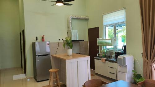 a kitchen with a refrigerator and a table in it at Duyong Damai Homestay by KOWBMAS in Melaka