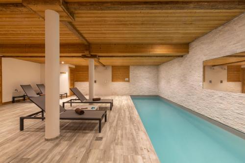 a swimming pool in a room with a brick wall at Chalet Crêt Beni in La Chapelle-dʼAbondance