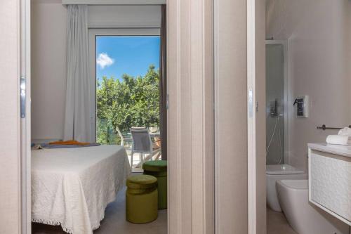 - une chambre avec un lit et une salle de bains avec une vue sur une baignoire dans l'établissement Modern villa with heated pool and sauna, à Marsala