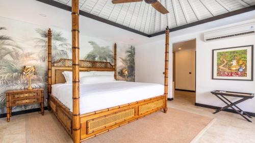 - une chambre avec un lit à baldaquin et un ventilateur dans l'établissement Kejora 12 Beachfront 3 br Luxe Villa, à anur