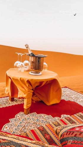 a table with a bucket on it on a rug at Riad Belvedere in Ouzina