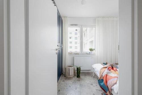 a white room with a bed and a window at Apartment with Balcony + Private parking / Bagry Lake in Krakow