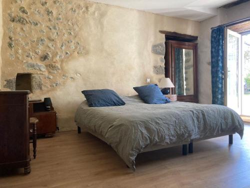 - une chambre avec un lit et des oreillers bleus dans l'établissement Les toits de Miramont, à Montesquieu-Avantès