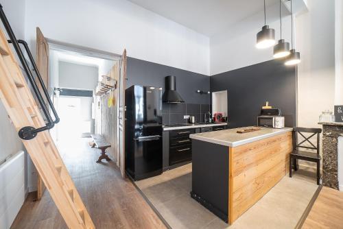 a kitchen with a black refrigerator and a counter at La Vie est Belle - Entre ski et thermes in Ax-les-Thermes