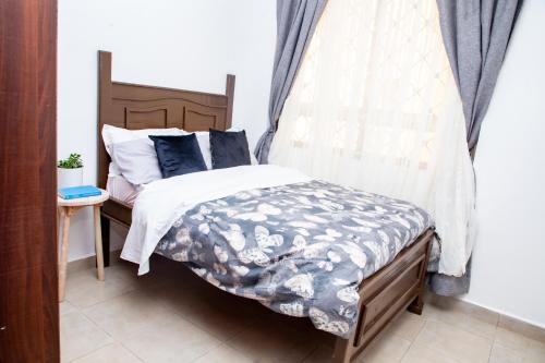 ein Schlafzimmer mit einem Bett mit blauen Kissen in der Unterkunft Pridelands Homes in Nairobi