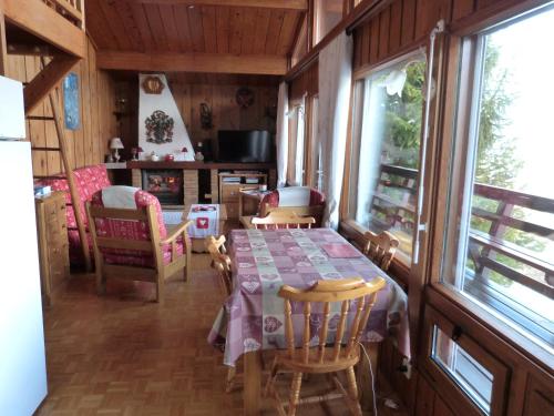 comedor con mesa y algunas sillas en Chalet Cèdre Rouge, en Enchastrayes