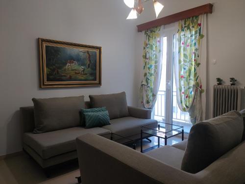 a living room with two couches and a window at Helen's downtown apartment in Ioannina