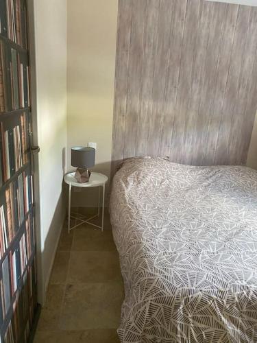 1 dormitorio con 1 cama y 1 mesa con lámpara en 2 pièces indépendant avec espace extérieur, en Caux