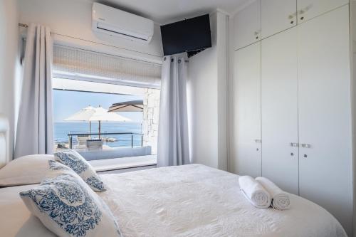 a bedroom with a bed with a view of the ocean at Clifton Sunset, Does have Power! in Cape Town