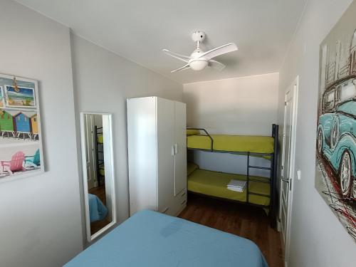 a bedroom with a bunk bed and a ceiling fan at Villablanca Apartamento in Chipiona