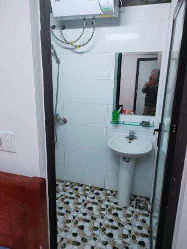a man taking a picture of a bathroom with a sink at Thanh Dũng Hotel Sapa in Sa Pa