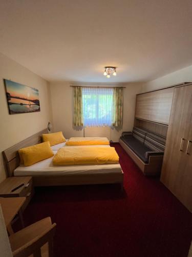 a bedroom with two beds and a couch at Ferienhof Wölflbauer in Saalbach Hinterglemm