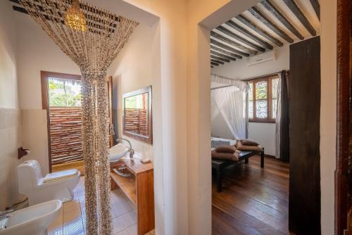 une salle de bains avec deux lavabos et une chambre dans l'établissement Beachfront Villa Hideaway ZanzibarHouses, à Kiwengwa