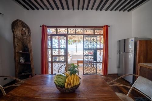 a room with a table with a bowl of bananas on it at Beachfront Villa Hideaway ZanzibarHouses in Kiwengwa